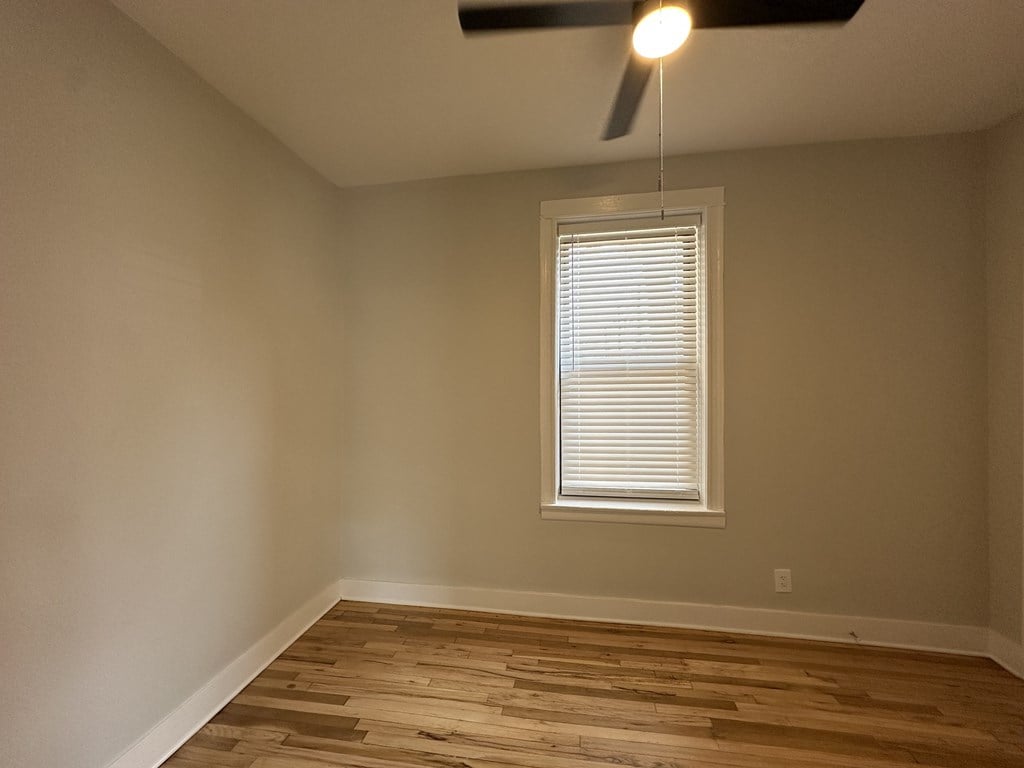 A room with a window and a ceiling fan.