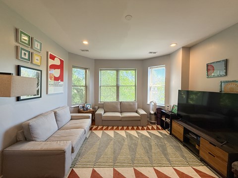 A living room with a large couch, a chair, and a television.