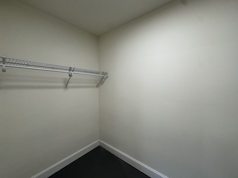A white wall with a metal rack on it.