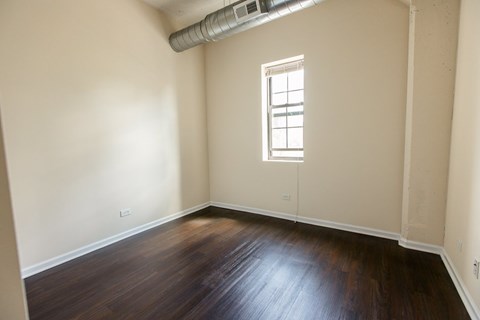 A room with wooden floors and a window.