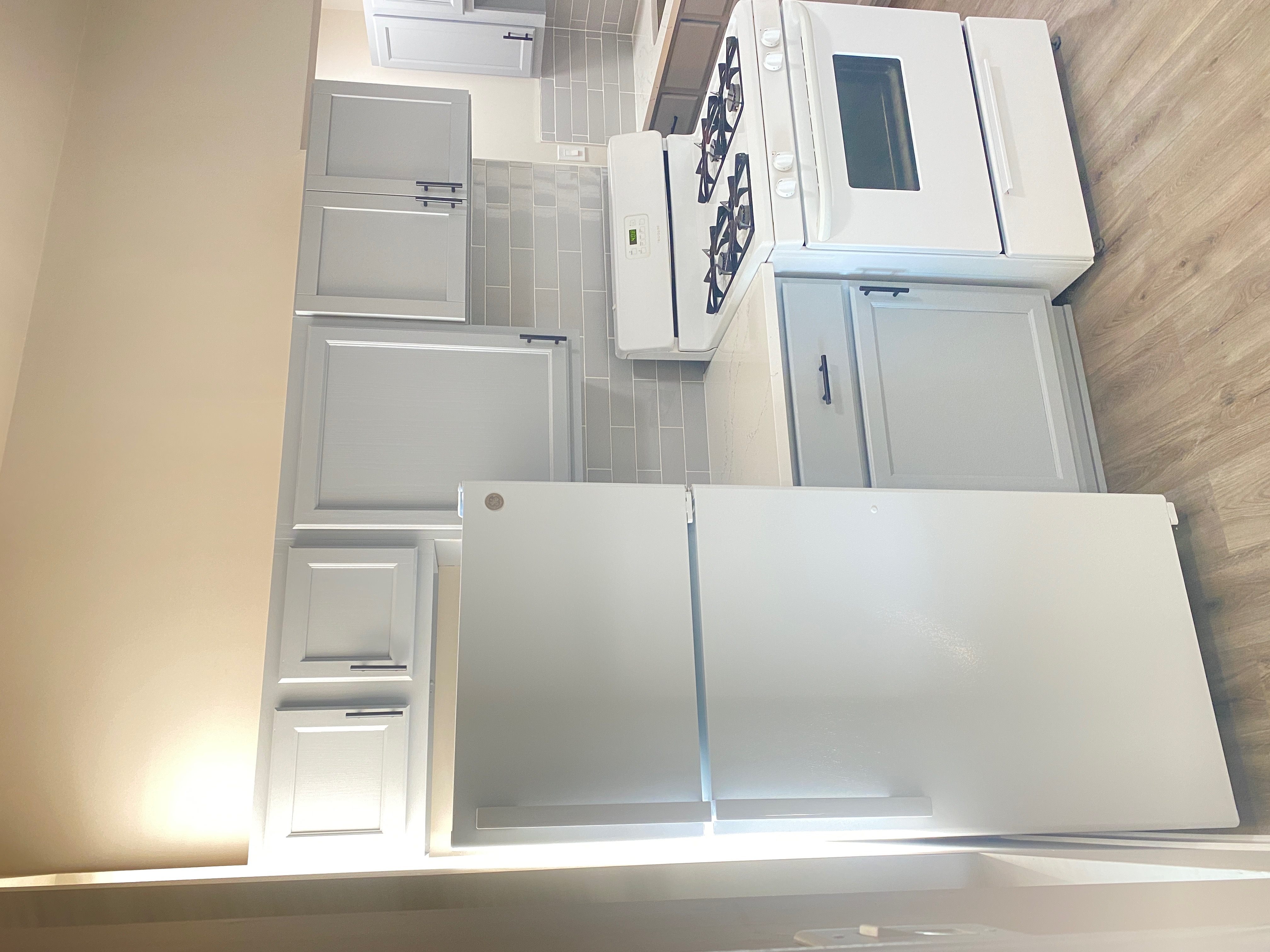 A kitchen with white appliances and cabinets.