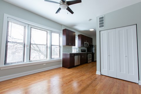 A room with a ceiling fan and wooden floors.