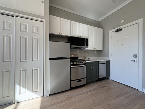A kitchen with white cabinets and a black stove top oven.