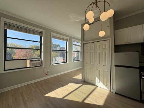 A kitchen with a white door and a window with trees visible outside.