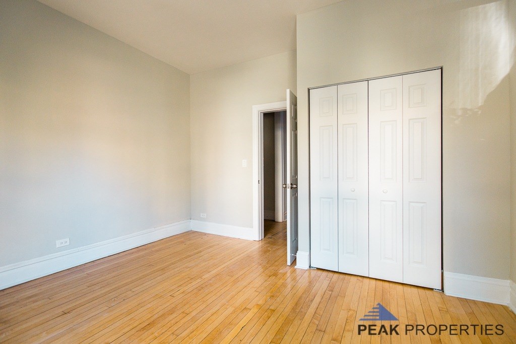 A room with a wooden floor and a white door.