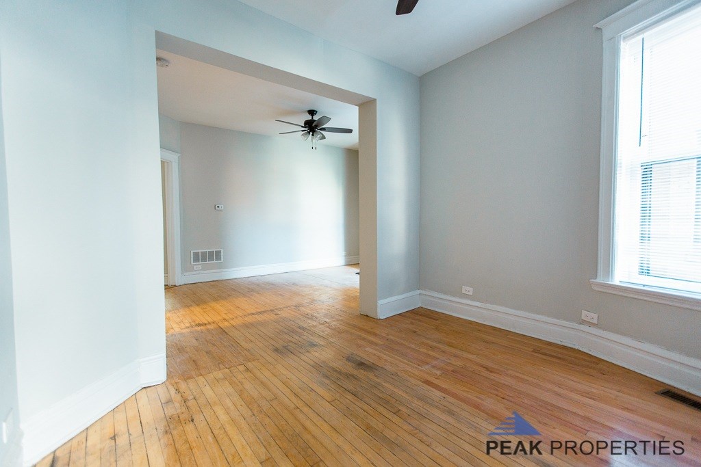 A room with wooden floors and a ceiling fan.