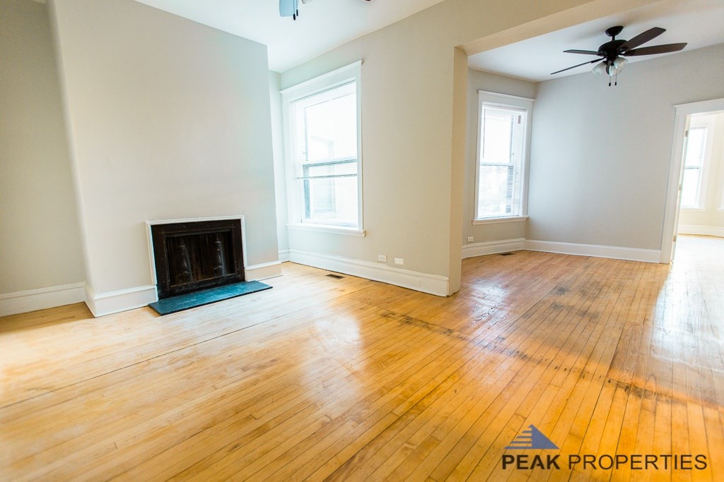 A living room with a fireplace and wood flooring.