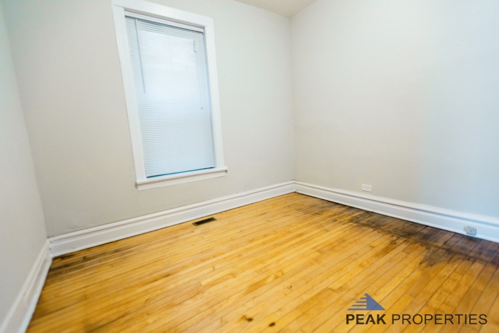 A room with a window and wooden flooring.