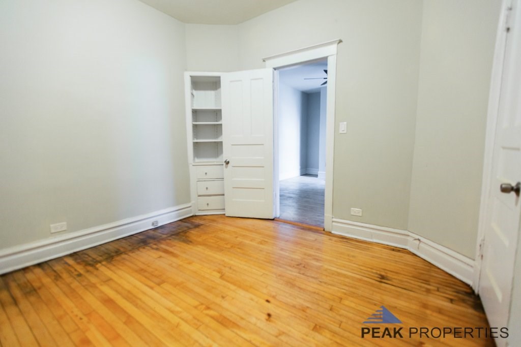 A room with a white door and a white cabinet with shelves.