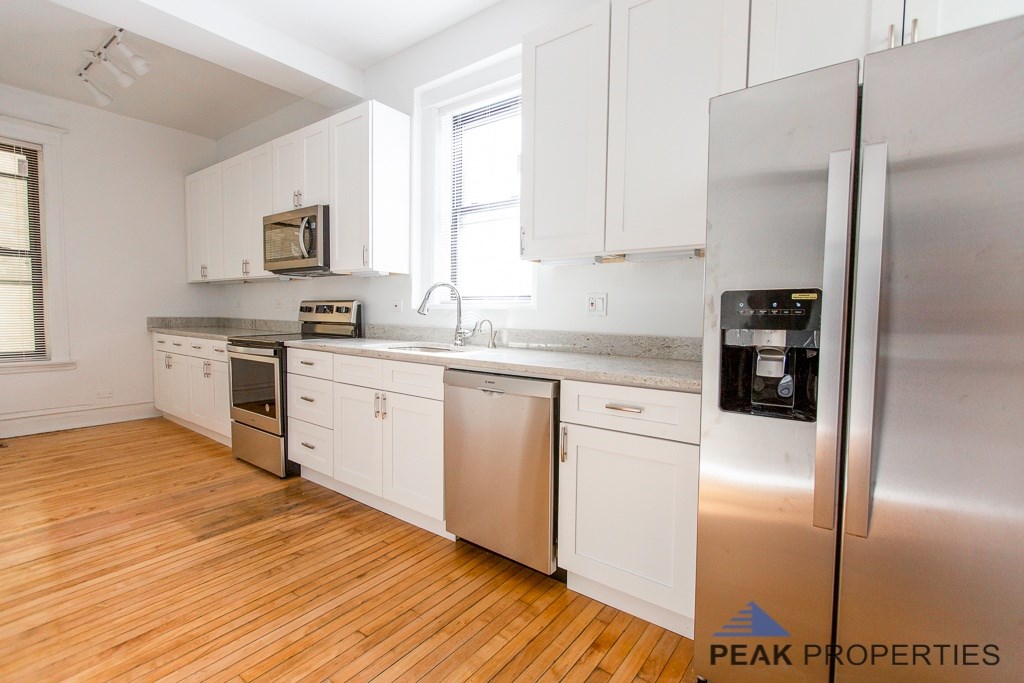 A kitchen with white cabinets and stainless steel appliances.