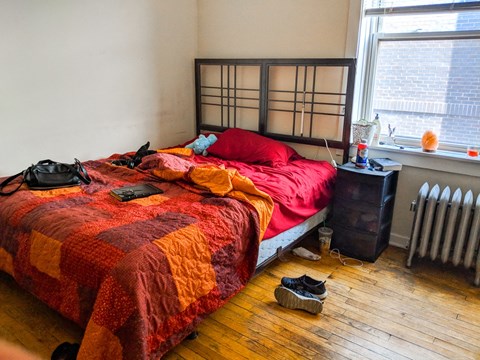 a bedroom with a bed and shoes on the floor