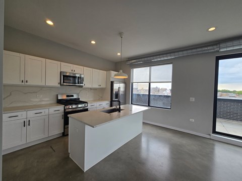 A kitchen with white cabinets and a large island.