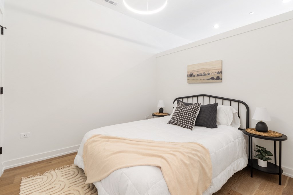 a bedroom with a bed with white sheets and pillows