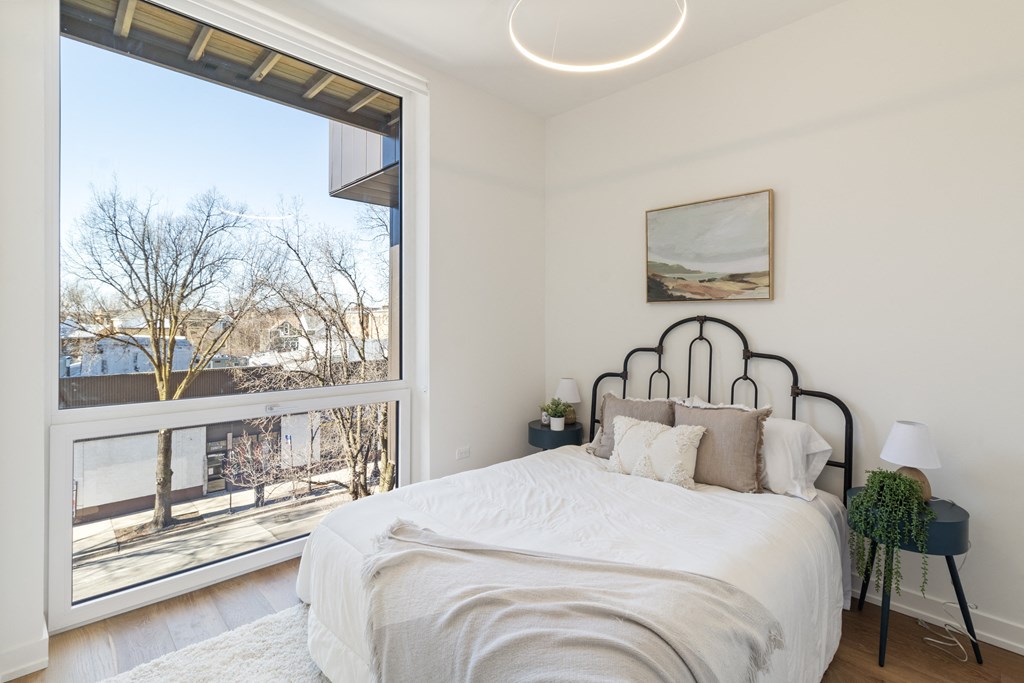 a bedroom with a bed and a large window