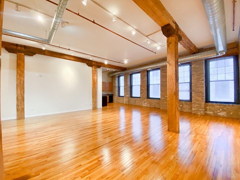 A large room with wooden floors and exposed beams.
