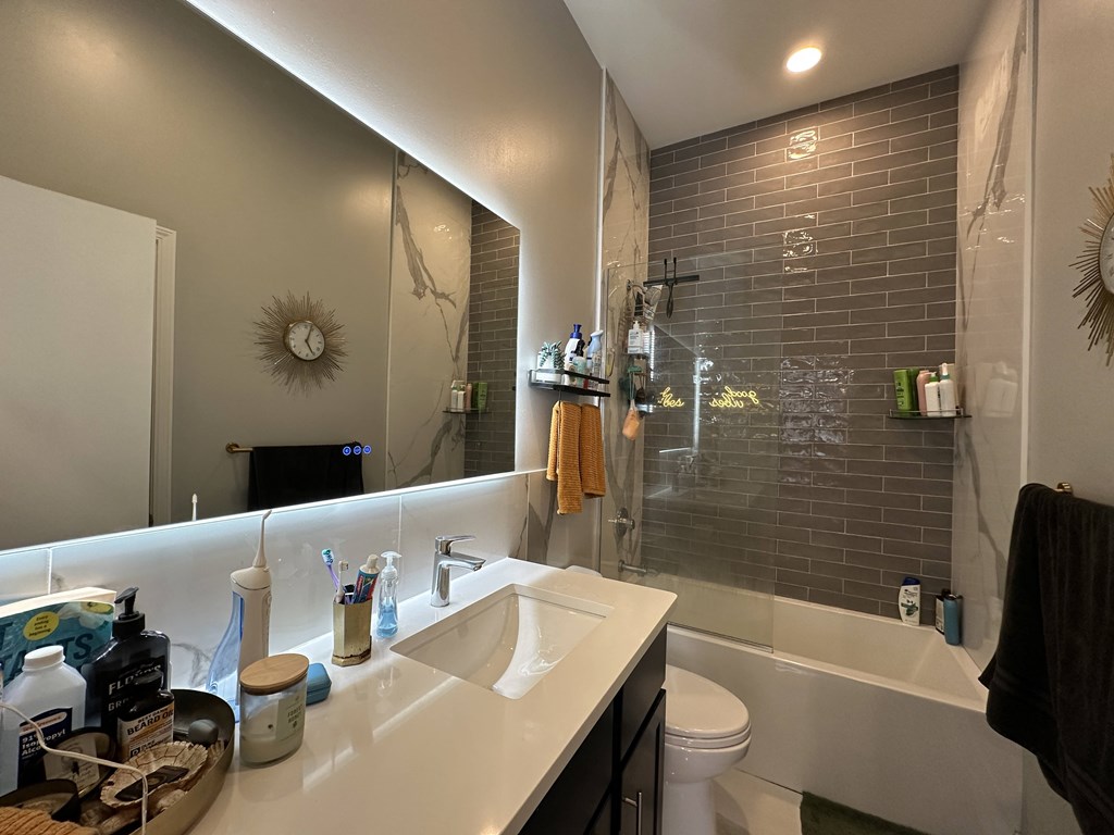 A bathroom with a white sink and a white toilet.