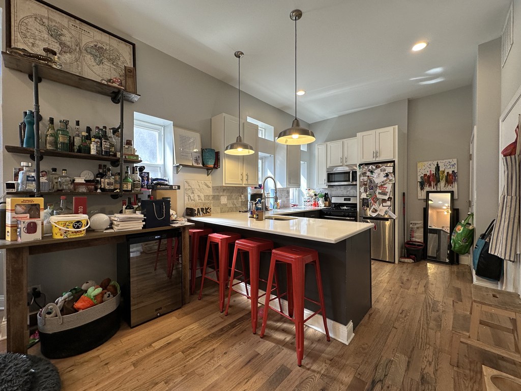 A kitchen with a bar area and a refrigerator.