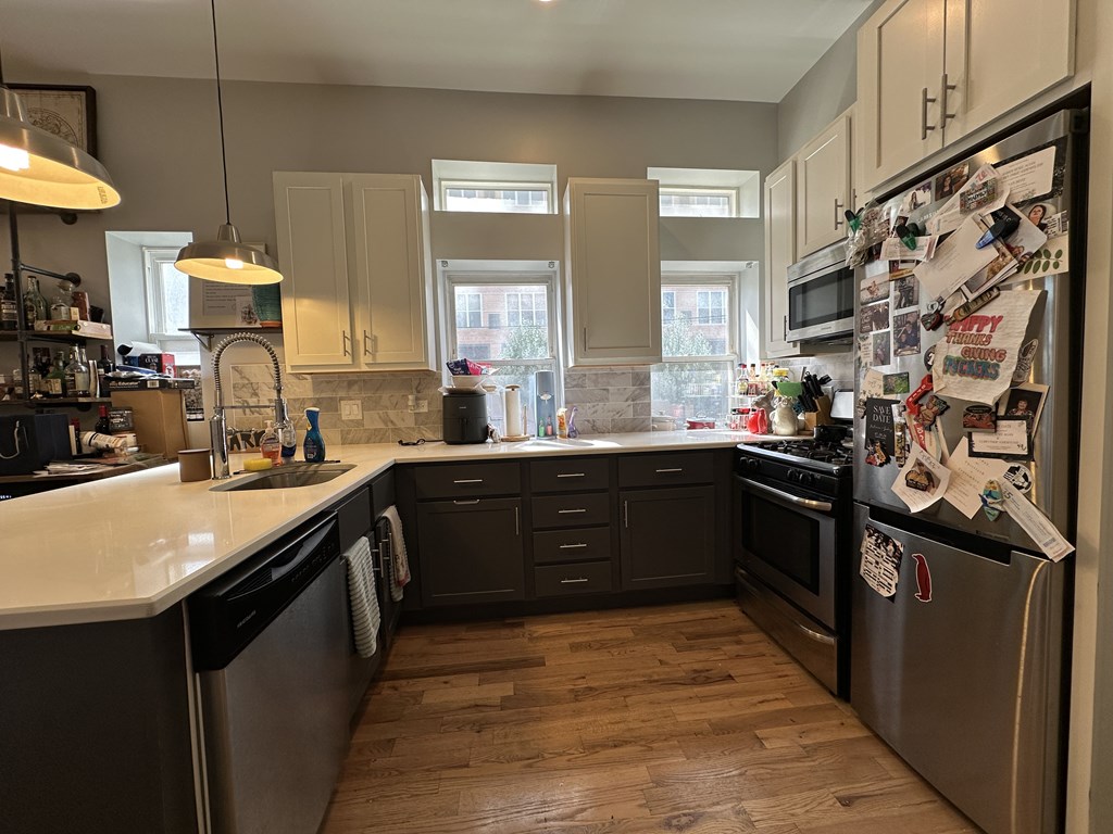 A kitchen with a refrigerator covered in papers and notes.