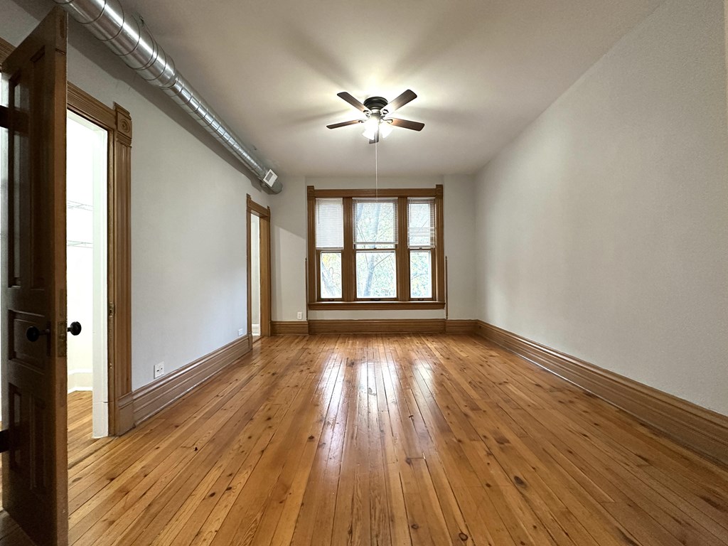 A room with wooden floors and a ceiling fan.