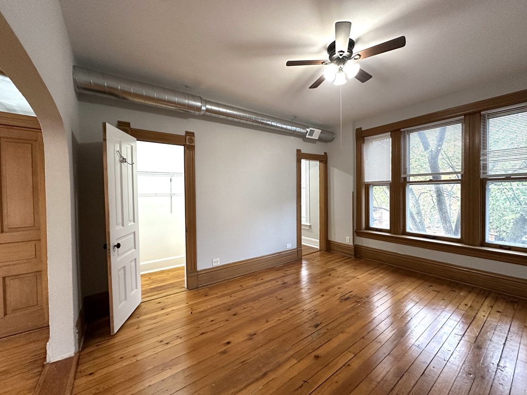 A room with wooden floors and a ceiling fan.