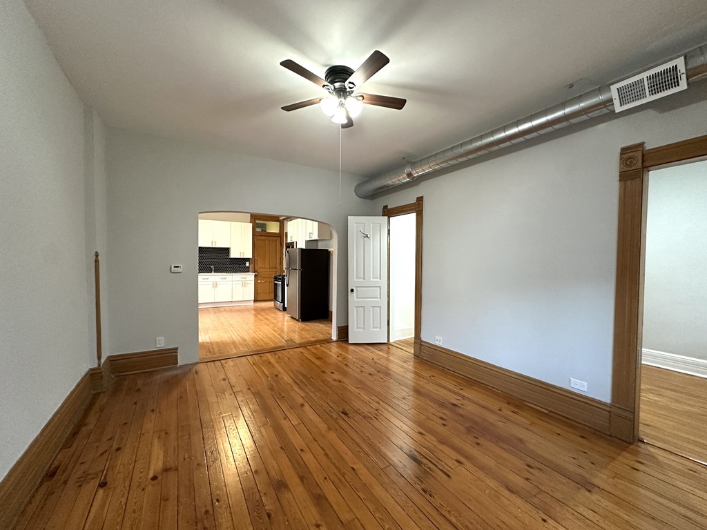 A room with wooden floors and a ceiling fan.