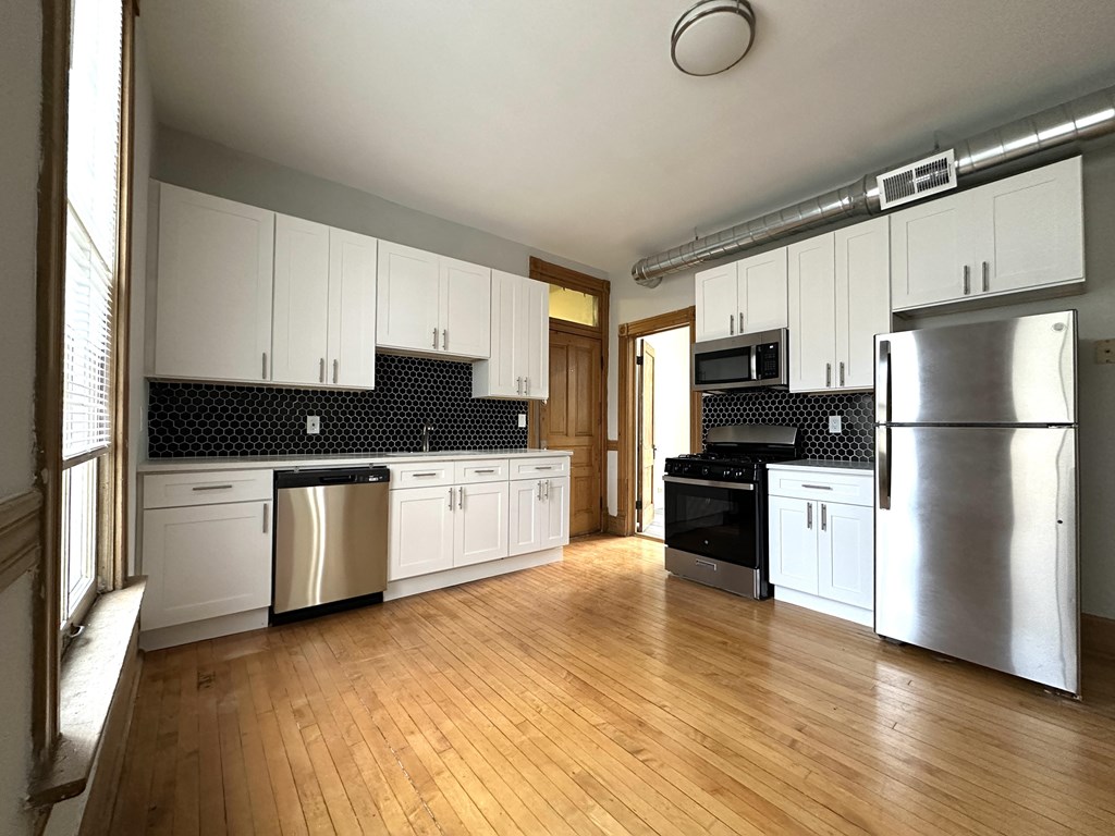A kitchen with wooden floors and stainless steel appliances.