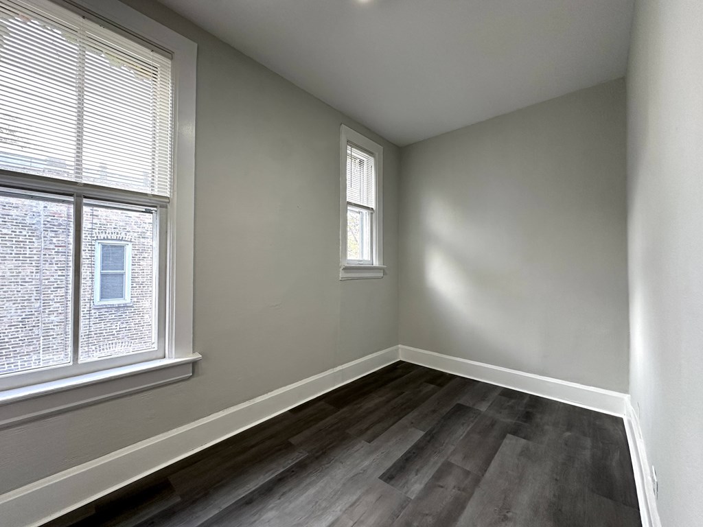 A room with a window and a smaller window on the wall.