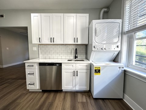 A white kitchen with a dishwasher and a washing machine.