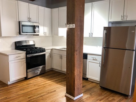 A kitchen with a refrigerator, stove, and oven.