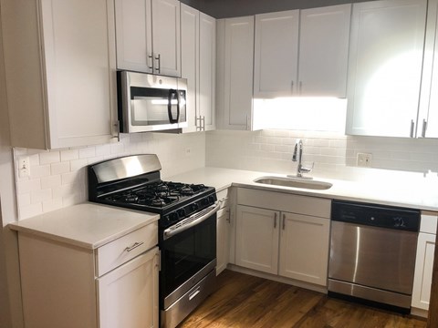 A kitchen with white cabinets and a black stove top oven.