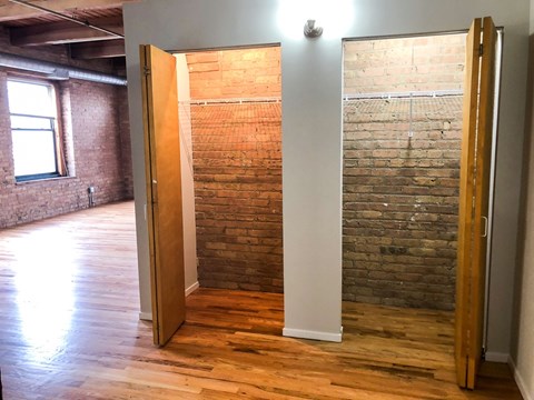 A room with a wooden floor and a brick wall.
