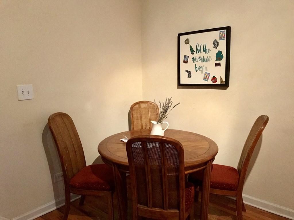 a dining room with a table and chairs and a picture on the wall