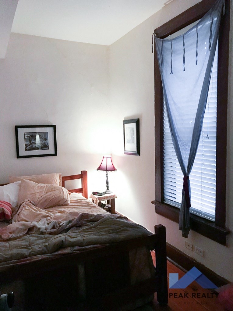 a bedroom with a bed and a window with blinds