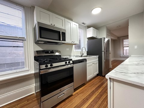 A kitchen with a stove top oven and microwave above it.