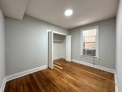A room with a wooden floor and a window.