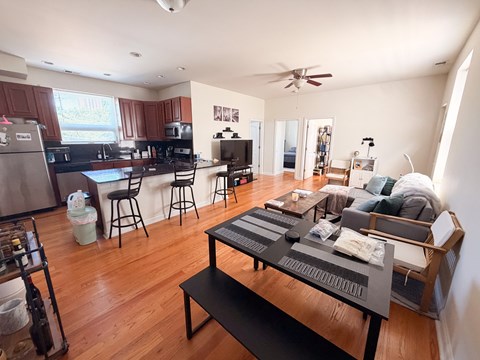 A modern kitchen with a breakfast bar and a living room with a couch.