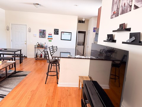 A living room with a bar area and a dining table.