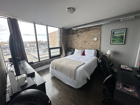 A bedroom with a large bed and a view of the city.
