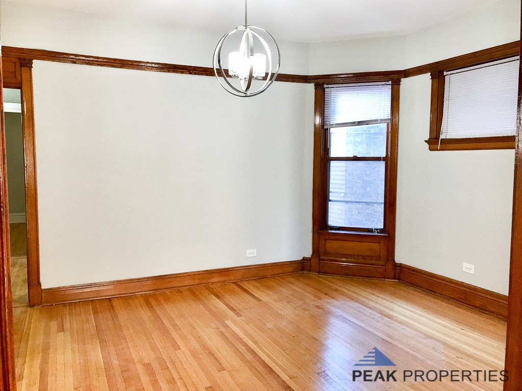 an empty living room with wood floors and white walls