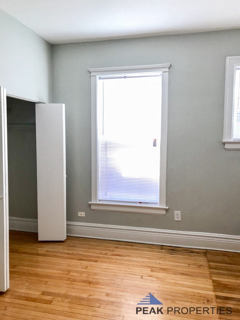 an empty room with a window and a closet