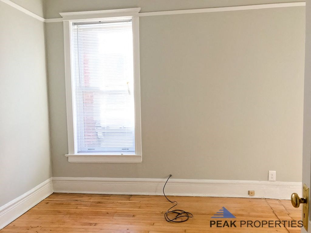 an empty room with a window and a cord on the floor