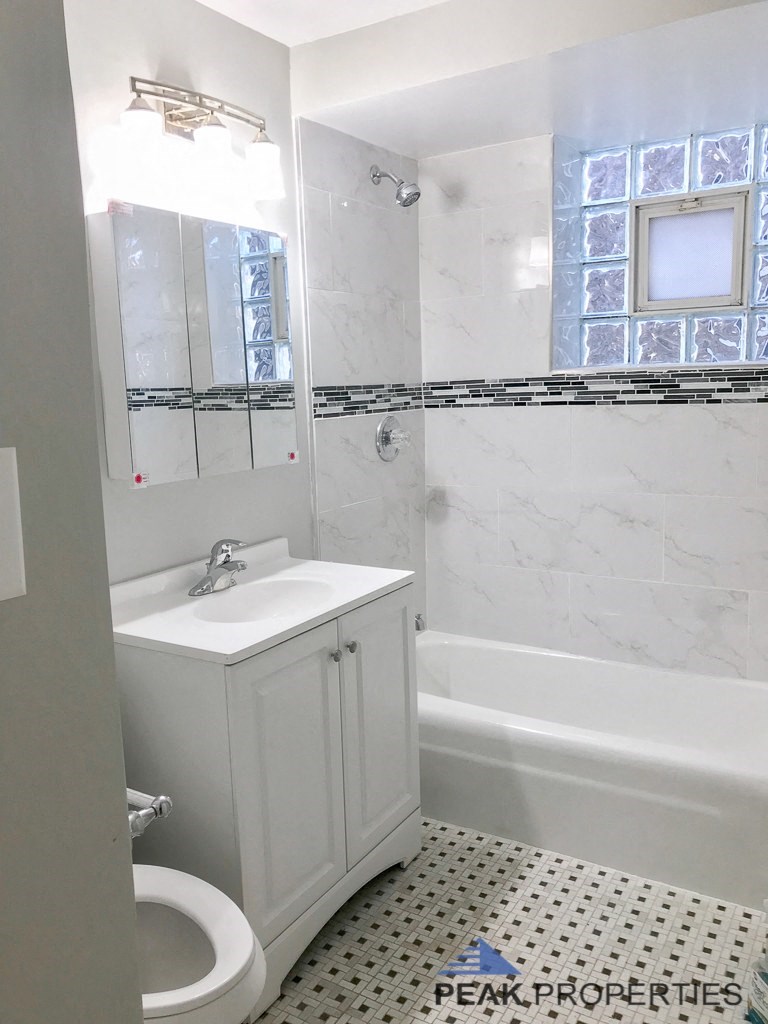 a white bathroom with a sink and a bath tub