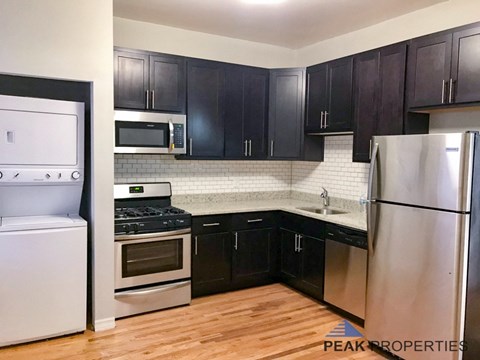 a kitchen with black cabinets and stainless steel appliances