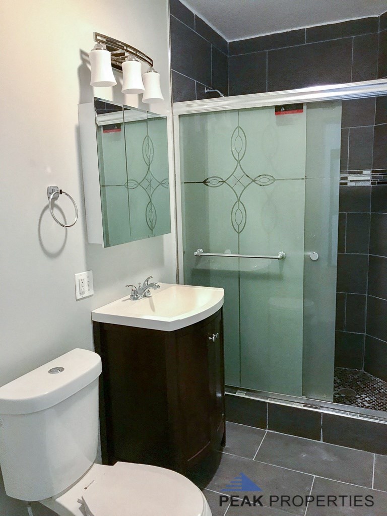 a bathroom with a toilet and a sink and a shower