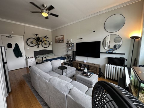 A living room with a grey couch and a black chair.