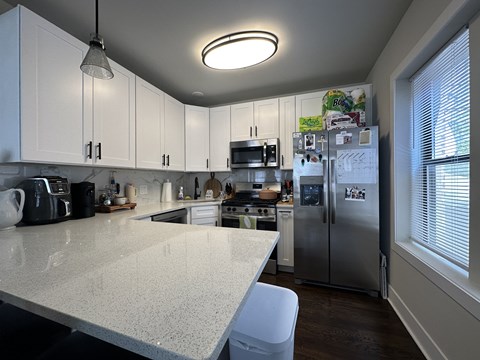 A kitchen with white cabinets and a white island.