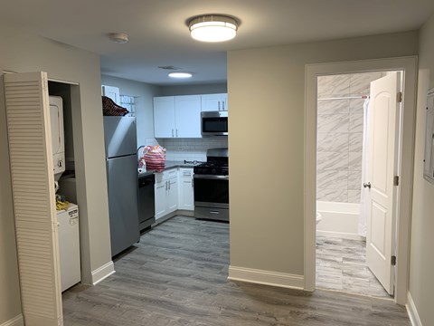A kitchen with a refrigerator, oven, and cabinets.