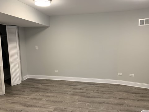 A room with a grey floor and a white ceiling with a light fixture.