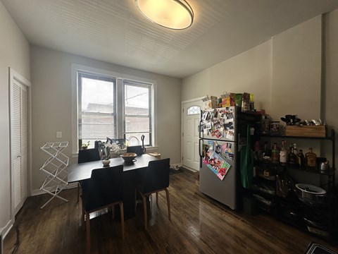 A kitchen with a table and chairs and a refrigerator with magnets on it.