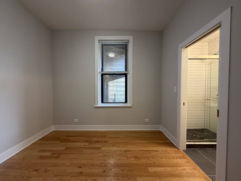 A room with a window and wooden flooring.